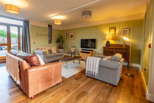 a living room with three couches and a tv at Marina View, Near Canal and Mountains in Brecon