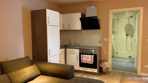 ein Wohnzimmer mit einem Sofa und einer Küche in der Unterkunft Aurellia Serviced Apartments in Wien