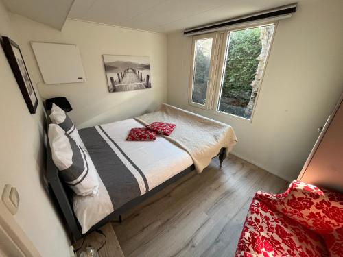 a small bedroom with a bed and a window at Tuinverblijf Lauwersmeer in Anjum