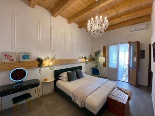 Un dormitorio con una cama grande y una lámpara de araña. en Atrium, en Castellammare del Golfo