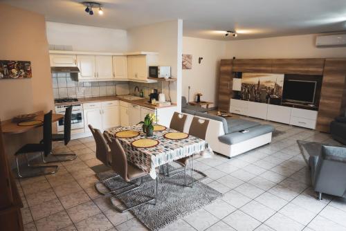 cocina y comedor con mesa y sillas en Bory Apartman, zárt udvari parkolás, en Székesfehérvár