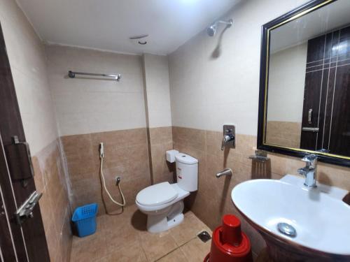 bagno con servizi igienici, lavandino e specchio di Hotel S.A International a Cox's Bazar