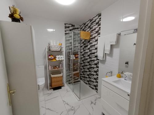 La salle de bains blanche est pourvue d'une douche et d'un lavabo. dans l'établissement APARTAMENTO ESTEL, à La Seu d'Urgell