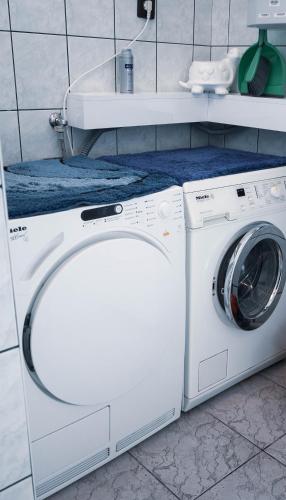 a white washer and dryer in a bathroom at Bory Apartman, zárt udvari parkolás, MET Aréna 2,5 km in Székesfehérvár