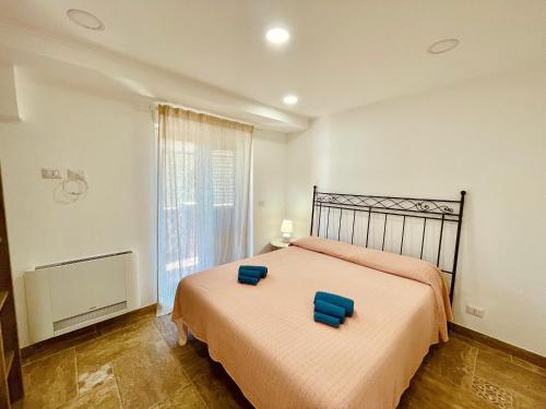 Un dormitorio con una cama con dos asientos azules. en La Casa di Alessandro, en Giardini Naxos