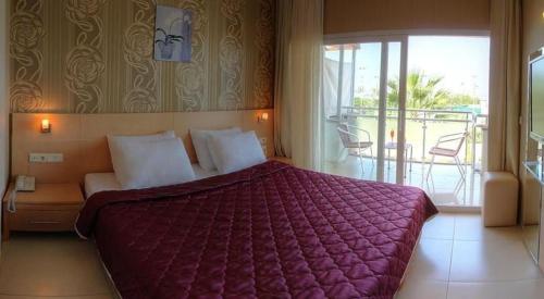 1 dormitorio con 1 cama grande y balcón en Marin-A Hotel & Spa Turgutreis, en Turgutreis