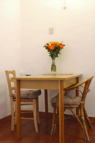eine Vase mit Blumen auf einem Tisch mit zwei Stühlen in der Unterkunft My Little Nest in San Lorenzo - Termini - Holiday Home in Rom