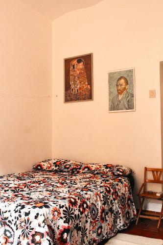 ein Schlafzimmer mit einem Bett und zwei Bildern an der Wand in der Unterkunft My Little Nest in San Lorenzo - Termini - Holiday Home in Rom