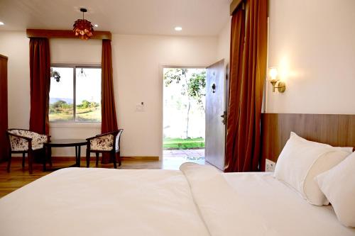 a bedroom with a bed and a table with chairs at The Serene Woods Resort in Matkuli