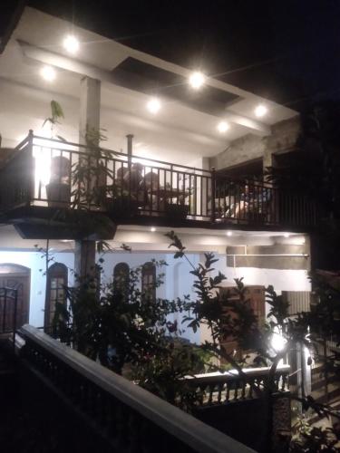a building with a balcony at night with lights at Farah Guest Inn in Haputale