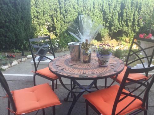 a patio table with chairs and flowers on a patio at Bryn Guest House in Conwy