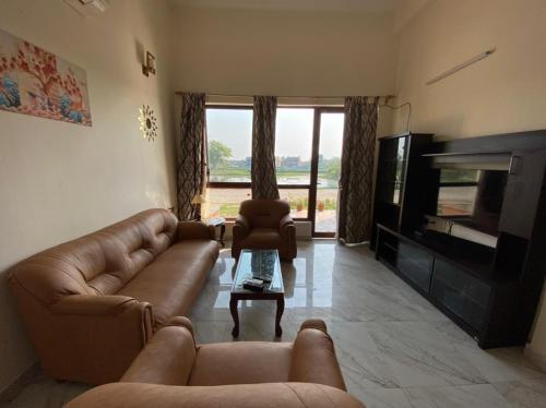 a living room with a couch and a television at Aqua villa vedic village in kolkata