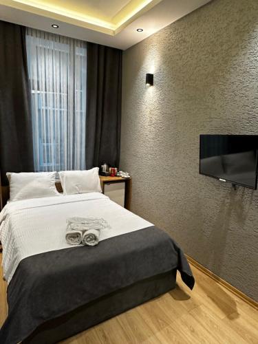 a bedroom with a bed and a flat screen tv at DAYMONTH HOTEL in Istanbul