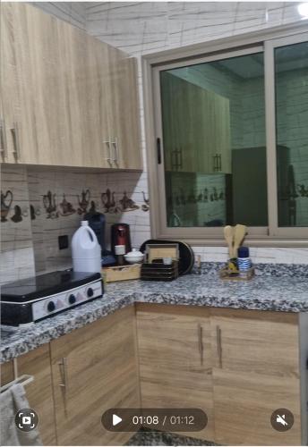 a kitchen with wooden cabinets and a counter top at Appartement Marjana in Meknès