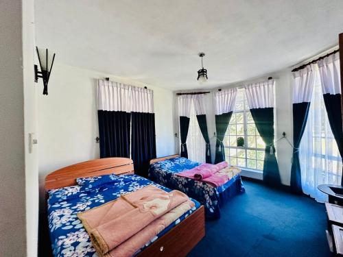 a bedroom with two beds and a window at Lakeside Cottage by Clover in Nuwara Eliya