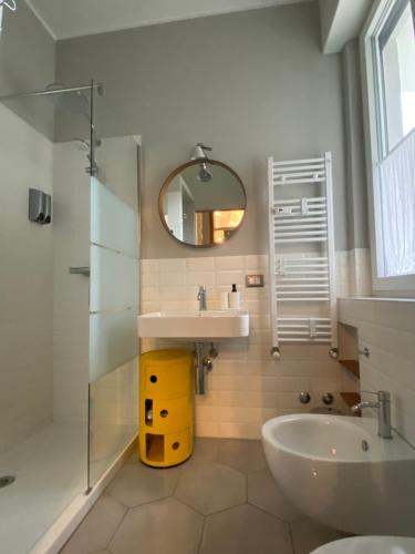ein Badezimmer mit einem Waschbecken, einem Spiegel und einer Badewanne in der Unterkunft The Silky Way in Como