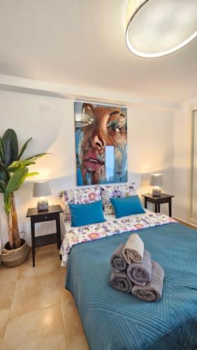 1 dormitorio con 1 cama con una pintura en la pared en Esmeralda Suites Sunrise, en Calpe