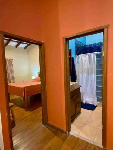 a room with a bedroom with a bed and a mirror at Casa Café Roatan, Honduras in Punta Blanca