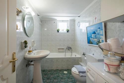 ein Badezimmer mit einem Waschbecken, einer Badewanne und einem WC in der Unterkunft Live Like a Local in Nafplio
