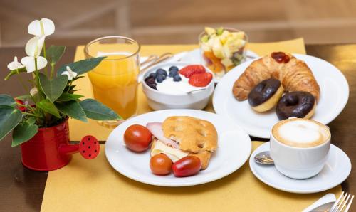 a table with plates of breakfast foods and a cup of coffee at Best Western Hotel Crimea in Turin