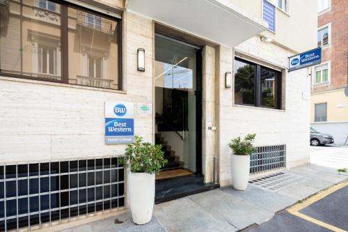 a store front with two potted plants in front of it at Best Western Hotel Crimea in Turin