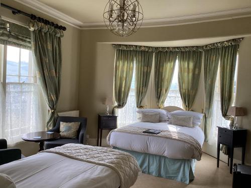 a bedroom with two beds and a chandelier at Bryn Guest House in Conwy