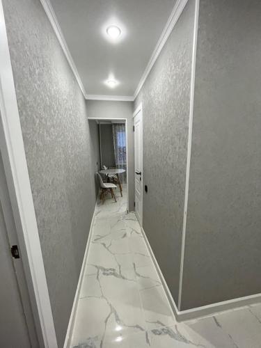 a hallway with a marble floor and a table at Уютная квартира в центре города in Aktobe