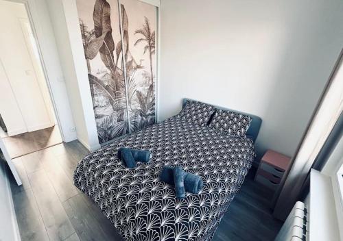 1 cama con 2 almohadas azules en una habitación en T2 moderne et neuf à 5 min de Lille-Centre, en La Madeleine