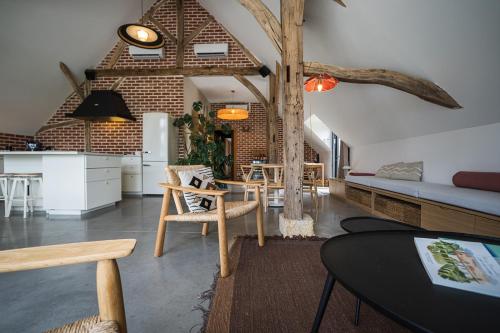 eine Küche und ein Wohnzimmer mit einem Tisch und einem Sofa in der Unterkunft La Grange De Léonie, Chambres d'hôtes avec Piscine et Spa in Méry-sur-Cher
