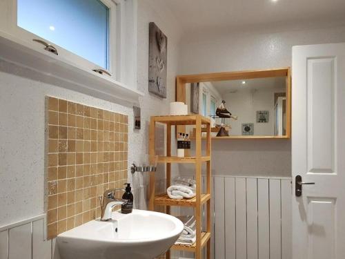 y baño con lavabo y espejo. en Loch Lomond Sanctuary Lodges en Balloch