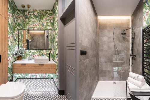 een badkamer met een douche, een toilet en een wastafel bij Lion Apartments - New Sopot by the sea! in Sopot