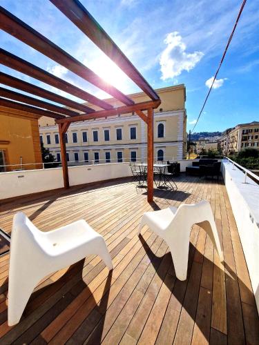 a deck with two white chairs on top of a building at Domus Neapolis Happy Holiday in Naples