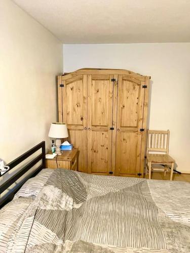 a bedroom with a large bed and a wooden cabinet at One Bed Flat by Colindale Tube station in Colindale