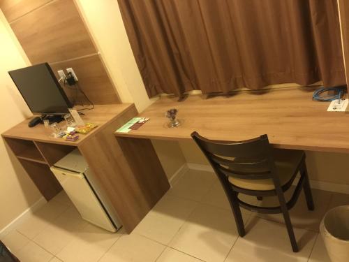 a desk with a computer and a chair in a room at Palace Hotel Campos dos Goytacazes in Campos dos Goytacazes