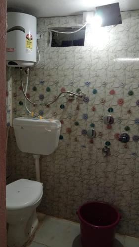 a small bathroom with a toilet and aperature at Hotel Parvati Stey Home Ujjain in Ujjain