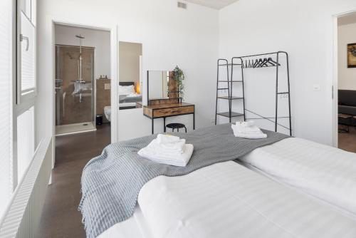 a bedroom with a large bed with towels on it at Casa Milla, Apartment Wuhr - Zentrales Loft am Fluss inklusive Parkplatz in Langenthal