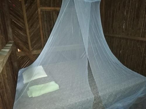 Una cama con una red encima. en Hospedaje Agroturismo Wounaan en Pidiaque