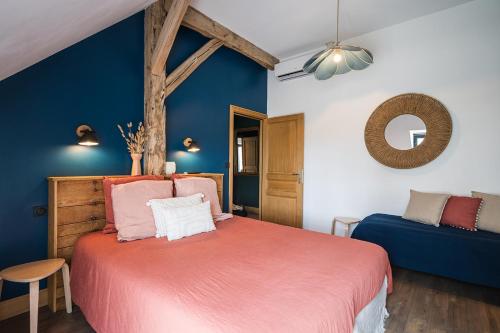 a bedroom with a red bed and a blue wall at Charmantes Maisons avec spas privatifs au calme Idéal weekend à 2 en famille ou entres amis in Vierzon