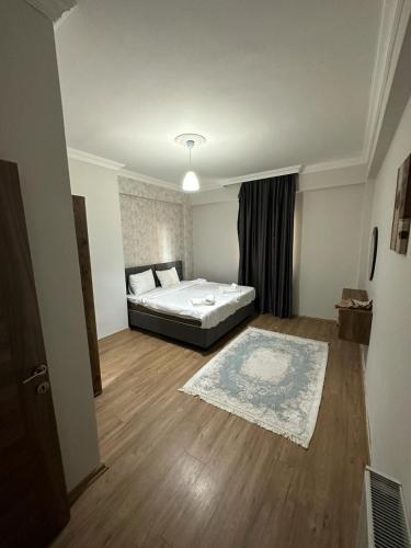 Schlafzimmer mit einem Bett und Holzboden in der Unterkunft فندق الصقر الذهبي in Pelitli