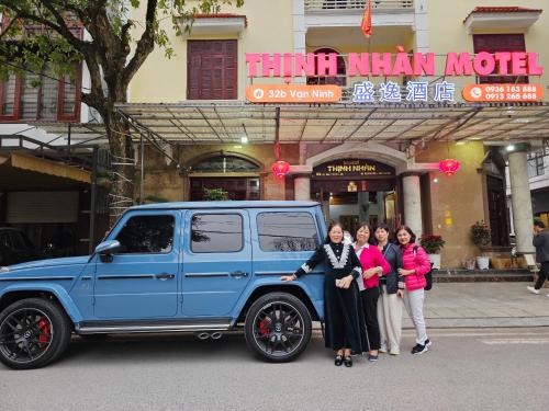 um grupo de pessoas ao lado de um jipe azul em Thịnh Nhàn motel em Móng Cái