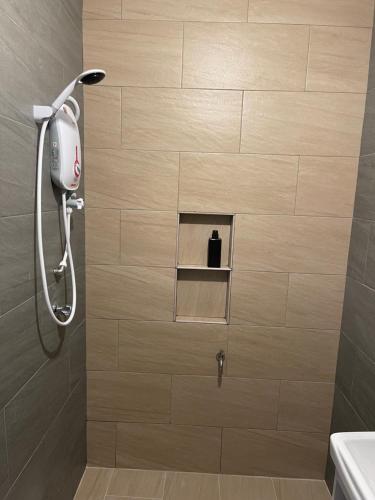 a shower with a shower head in a bathroom at Homestay Studio TOKAYOH in Kota Bharu