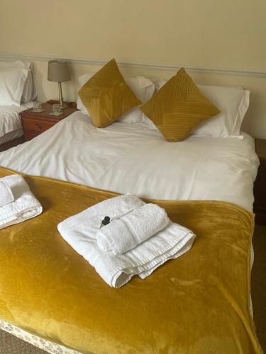 a bed with two towels and two pillows on it at The Kings Arms Inn in Yeovil
