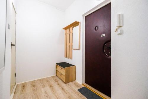 einen Flur mit einer braunen Tür und einem Holzschrank in der Unterkunft Apartman Sweet home in Humenné