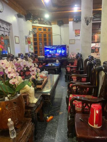 Thịnh Nhàn motel في Móng Cái: غرفة بها كراسي وطاولات وتلفزيون وغرفة بها غرفة
