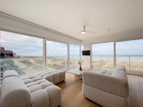 a living room with couches and a view of the ocean at Hoekappartement 'Westdiep' met zeezicht te Oostduinkerke - Bad in Oostduinkerke-Bad