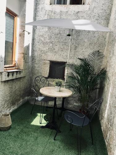 une table et des chaises dans une terrasse avec une plante dans l'établissement LE PASTORE avec Terrasse Au Coeur du Centre Historique, à Dijon