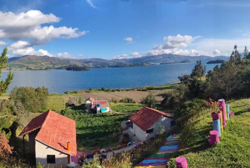 a small house on a hill next to a body of water at Cabañas Villas Del Lago in Cuítiva