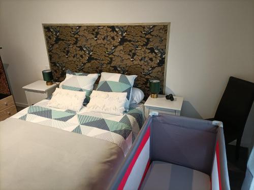 een slaapkamer met een bed en twee nachtkastjes bij Comme à la maison in Gannat
