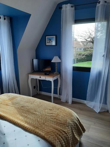 um quarto com uma cama e uma secretária com uma janela em Le Refuge du Hibou em Beaurains