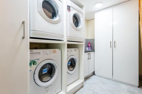 eine Waschküche mit 3 Waschmaschine und Trockner in der Unterkunft Private Rooms With Private Bathrooms In Selly Oak Birmingham in Birmingham